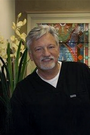 Dr. Ed Trizzino from Smiles of Atlanta standing in the clinic lobby in his scrubs